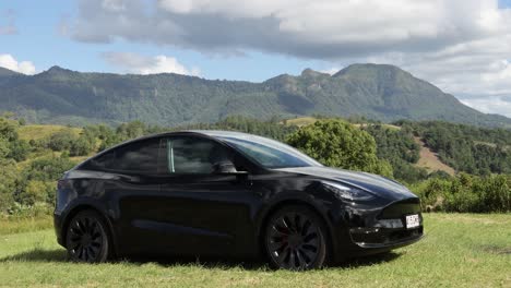 black car parked in lush valley landscape