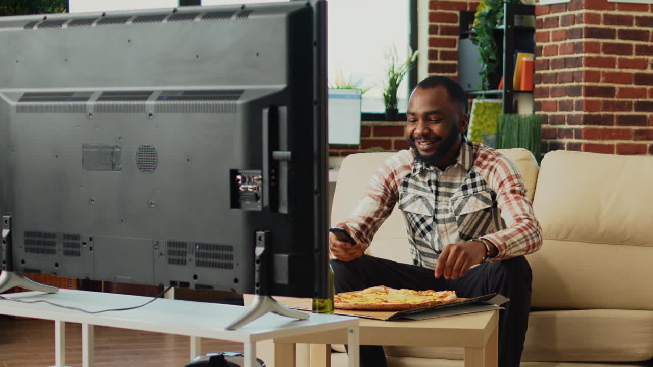 African american man serving slice of pizza at home