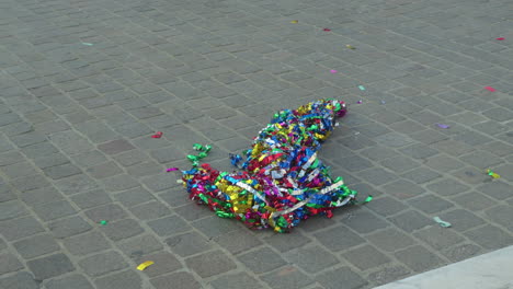 colorful candy wrappers strewn on cobblestone after a parade