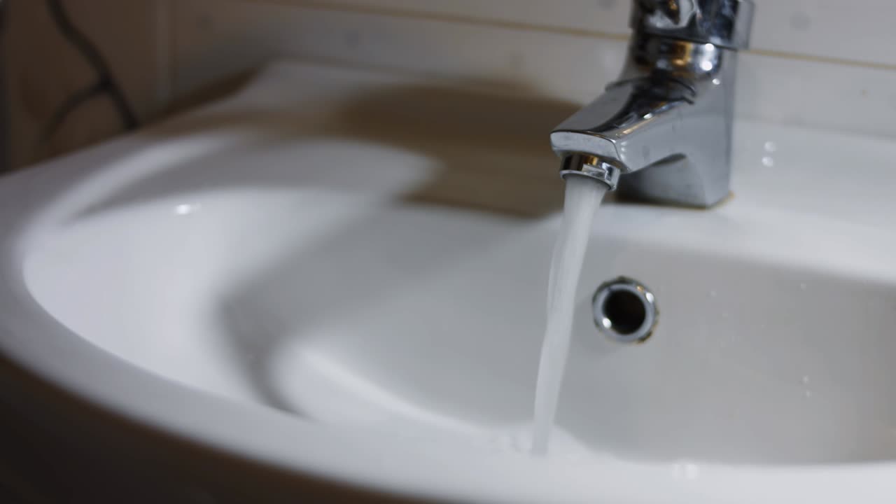pantalla de teléfono móvil en la mano bajo el agua en un lavabo. prueba de pantalla de teléfono celular para la resistencia al agua. video 4k