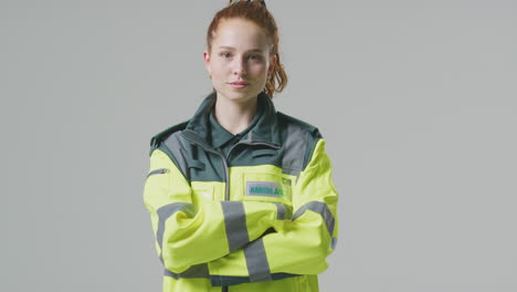 Full-Length-Studio-Portrait-Of-Serious-Young-Female-Paramedic-Against-Plain-Background