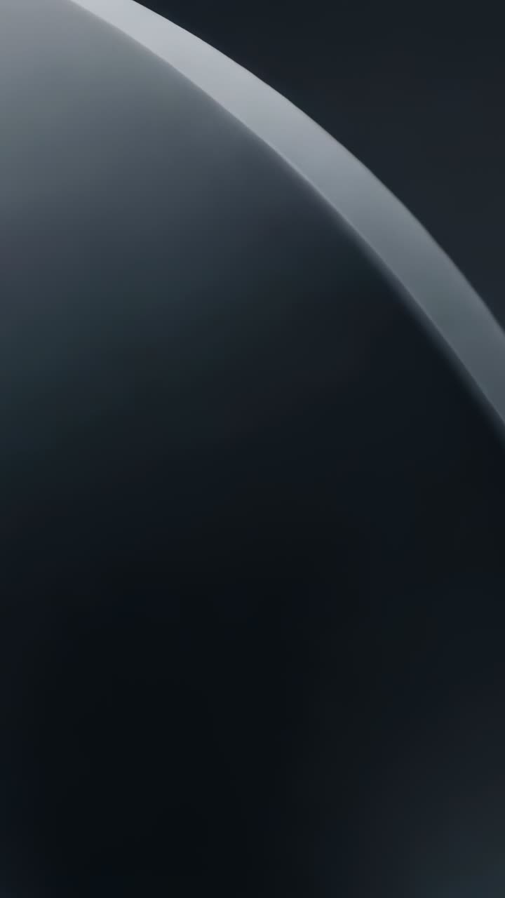 Vertical video: Panning camera revealing dark sphere in studio, showing thin rim to emphasize curve