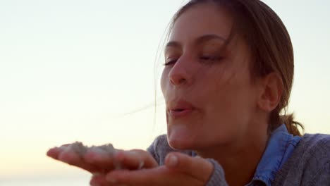 Woman-blowing-sand-in-the-beach-4k