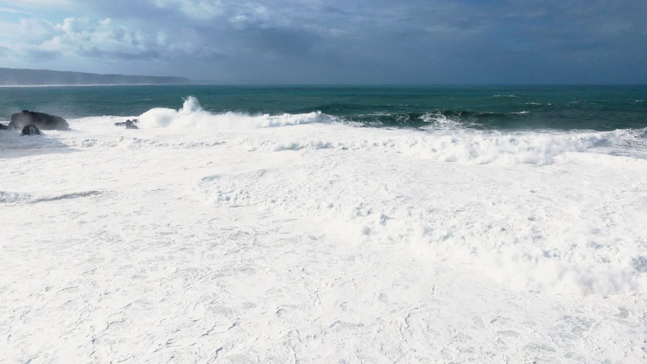 Aerial drone over Nazaré, Portugal, giant Atlantic swell. Surfers and jet ski teams waiting near shore