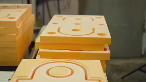 stacks of precision-cut orange foam pieces for industrial use, with visible cut patterns