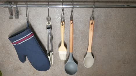 close-up of a variety of kitchen utensils hanging on a rack