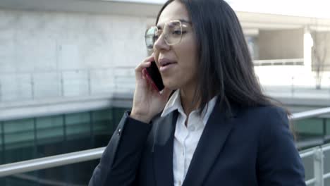 Smiling-businesswoman-with-paper-cup-using-smartphone