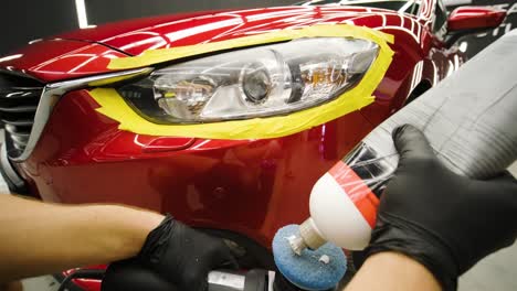 headlight polishing, processing of car lights. a car service worker polishes the headlight of a passenger car. professional polishing.