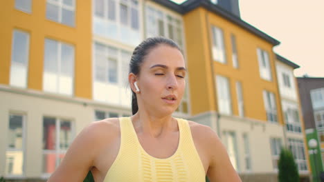 to complete the exercise of warm-up and warm-up muscles before training. a woman in the park in headphones performs a hitch with stretching after a successful fitness workout. restoring strength