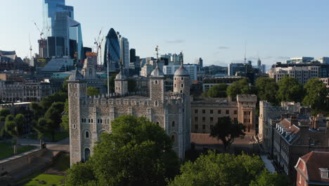 Fly-around-medieval-part-of-Tower-of-London.-Historic-royal-castle-contrasting-with-modern-skyscrapers-in-city-financial-hub-in-background.-London,-UK