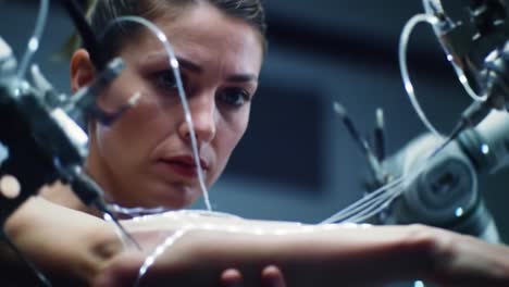 a focused woman undergoing a high-tech procedure with intricate robotic mechanics and light threads on her arm in a futuristic environment