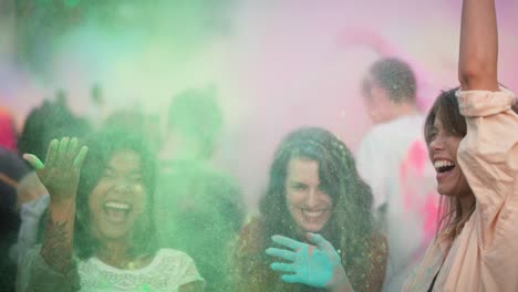 Group-of-friends-holding-coloured-powder-and-throwing-up-at-Holi-Festival