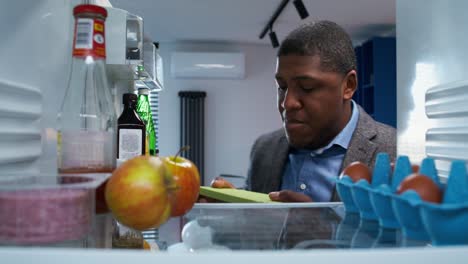 Man looking for food in a refrigerator
