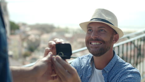 vista frontal de un gay caucásico sonriente proponiendo a un amante al aire libre