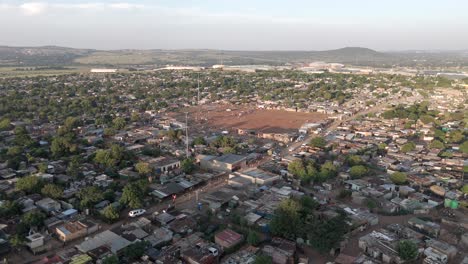 stunning 4k aerial footage, a push-in and tilt downward drone shot gracefully unveils the scenic beauty of a rural township in south africa