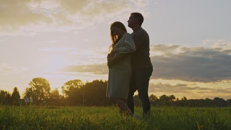 pregnant couple at sunset