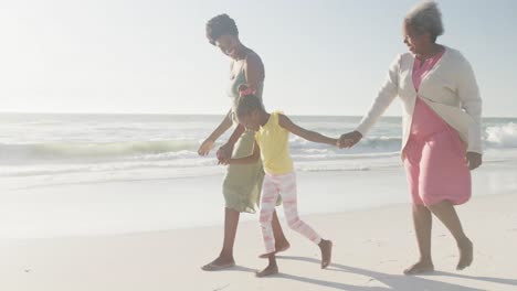 Feliz-Abuela-Afroamericana,-Madre-E-Hija-Caminando-En-La-Playa,-En-Cámara-Lenta