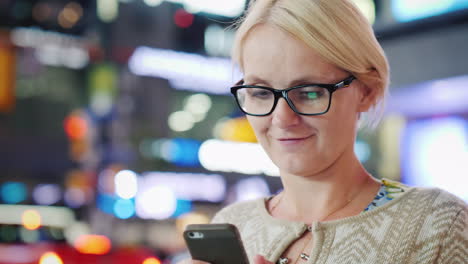 woman texting in city at night