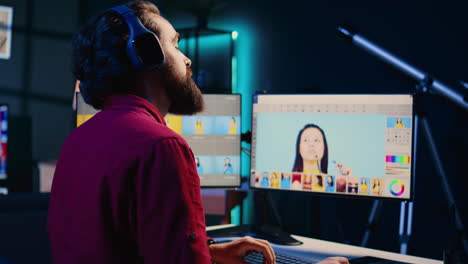 photo editor selecting best photographs while listening music in headphones