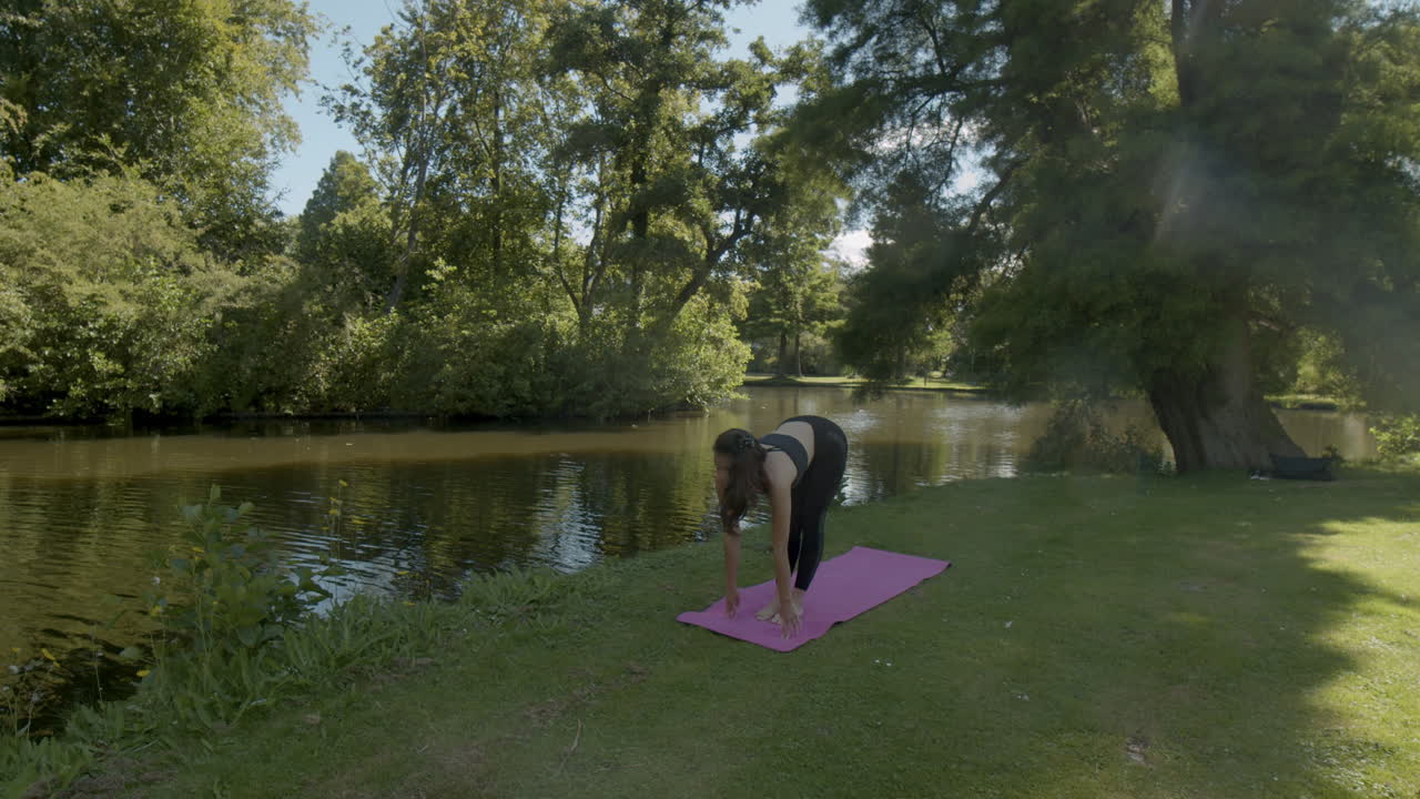 mujer joven haciendo ejercicios de yoga de equilibrio en un hermoso parque