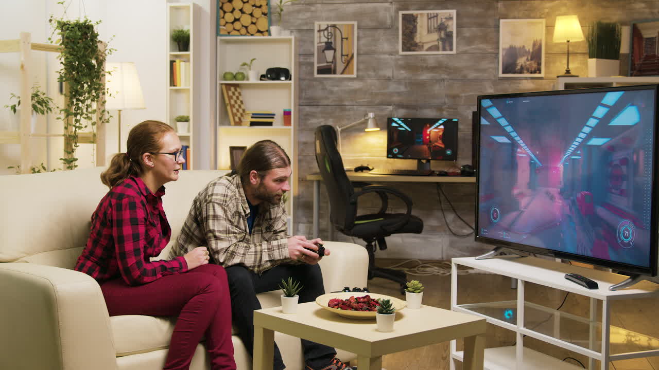 Couple playing video games on TV in living room
