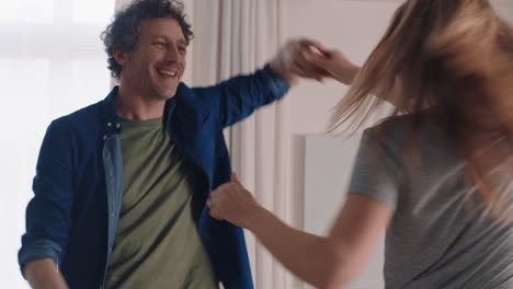 una pareja joven feliz bailando juntos en casa celebrando divirtiéndose el fin de semana sonriendo disfrutando de un baile divertido en la sala de estar celebrando una relación exitosa imágenes en 4k
