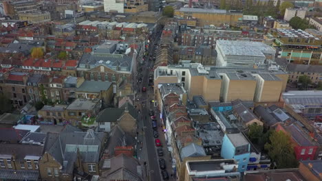 Low-aerial-flyover-of-quaint,-narrow-Brick-Lane-in-London,-UK