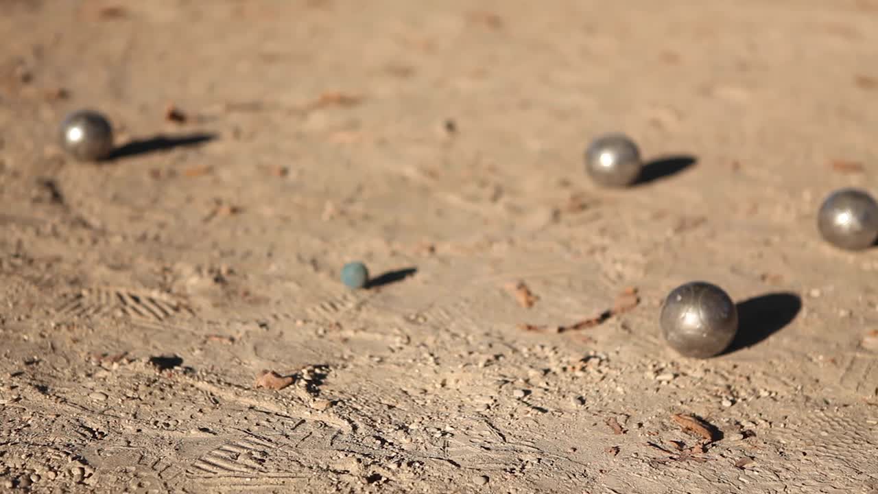 야외에서 페탄크를 치는 동안 금속 공의 충돌: 페탄크 선수가 손에 금속 공을 들고 여름 오후에 파리의 이 많은 공원에서  바닥에서 총을 는 금속 충돌.