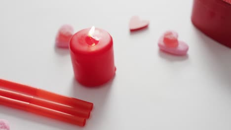 dulces en forma de corazón y velas en fondo rosa en el día de san valentín