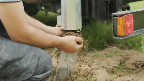 man putting black soil into pack. soil examination of agronomy. geotechnical investigation. collecting black soil on the field for examination and analysis. special equipment for pickup