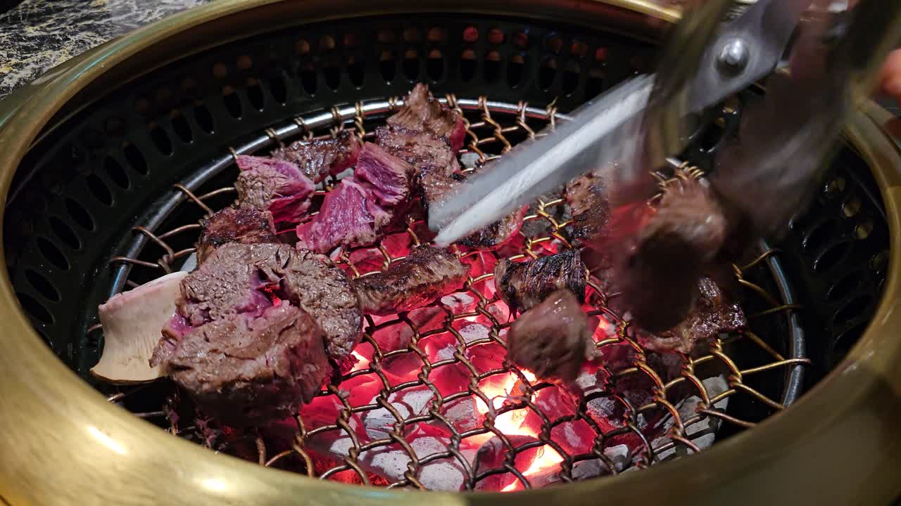 At Hanu Beef Korean restaurant, tender beef is grilled over glowing charcoal and cut with scissors for a perfect barbecue experience