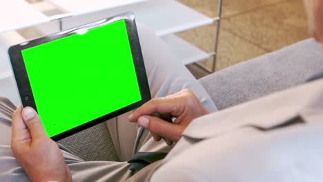 hombre de negocios usando una tableta sentado en el sofá
