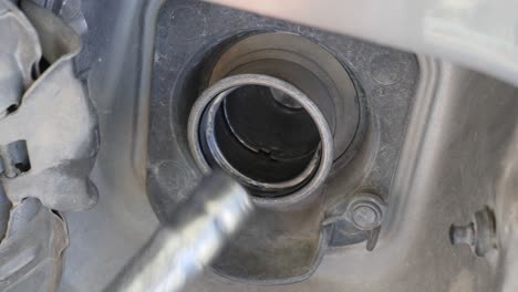 close-up of a fuel nozzle being removed from a vehicle's gas tank