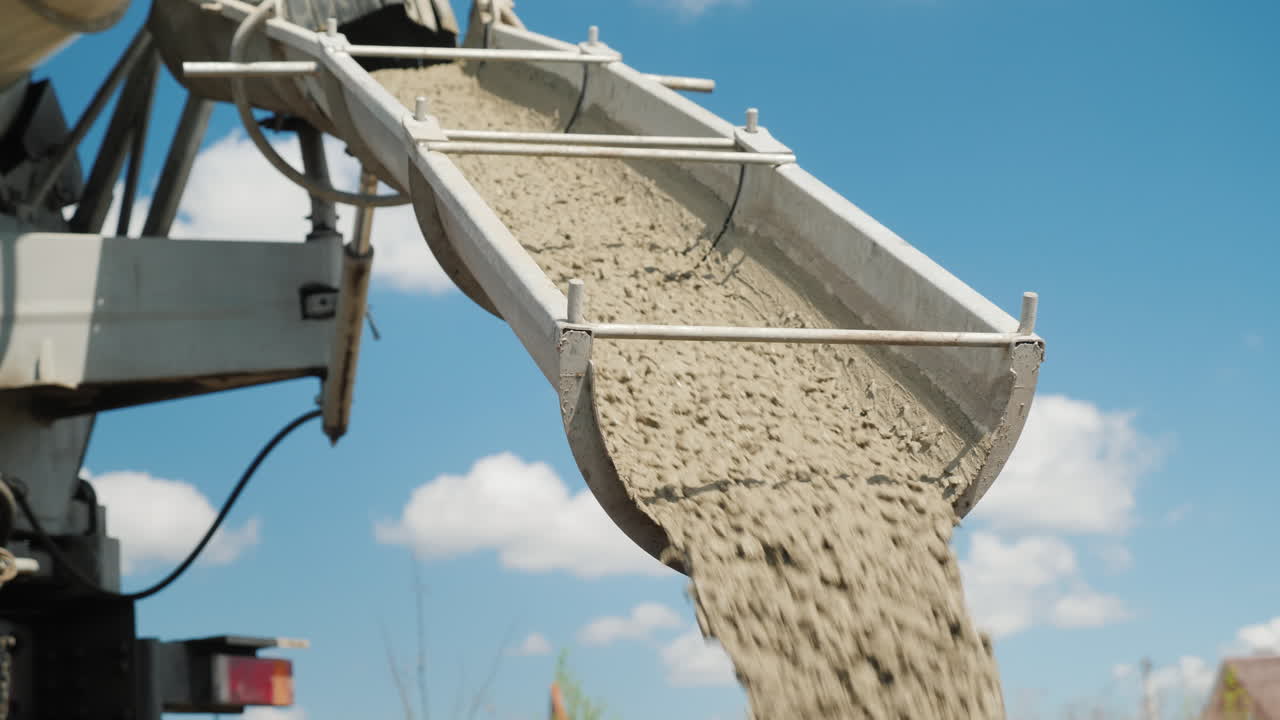 콘크리트는 시골집의 푸른 하늘 건설에 대해 콘크리트 믹서에서 내립니다.