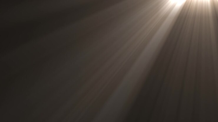 Raggi di luce dorati che brillano attraverso uno sfondo scuro
