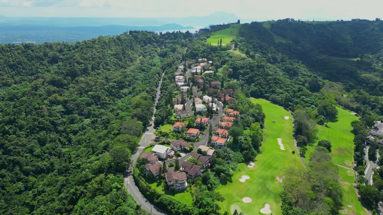 A closing-in aerial of villas in Tagaytay Highlands surrounded by pine trees and winding roads in Batangas, Philippines
