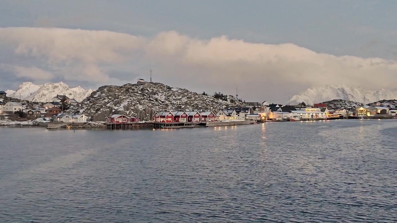 Fredelig kystlandsby i Svolvær, Norge, med naturskjønne snødekte fjell.