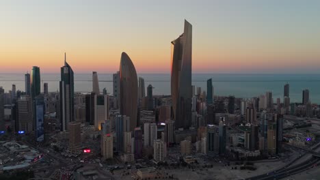4k drone aerial of kuwait city during golden hour. towers silhouetted against a vibrant sunset sky over the gulf. ideal for real estate, tourism, and urban themes.
