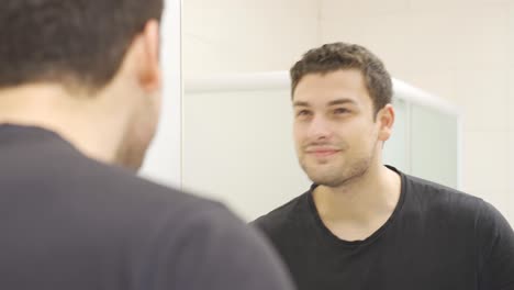 Schöner-Mann-Glättet-Seine-Haare-Im-Spiegel.