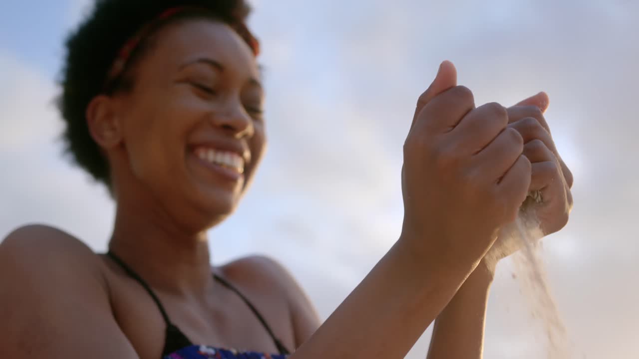 African american woman playing with sand 4k