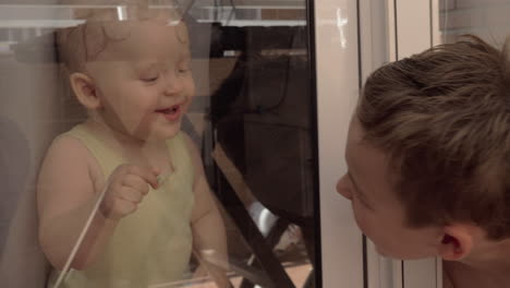 Children-smiling-to-each-other-through-the-window