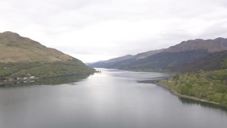 aerial over calm loch lomond with mountains on either side