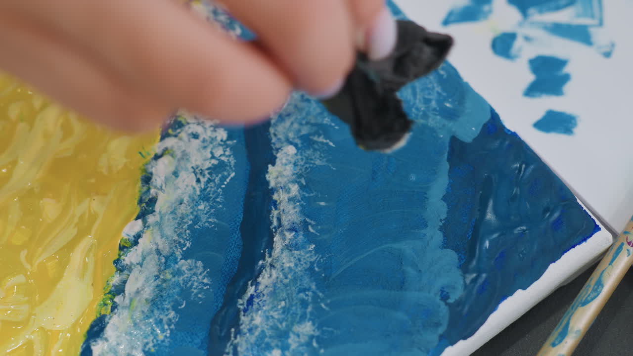 미묘한 하이라이트를 넣는 여성의 손, 작은 도구를 사용하여 예술 작품을 다듬는 여성 작업자, 작은 도구로 레이어 아트워크에 마무리 손길을 더하는 여성의 손 클로즈업