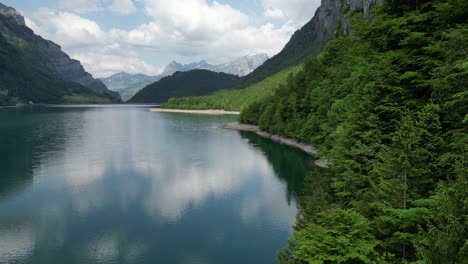 Beautiful-Switzerland-Alpine-lake-scenery-with-green-trees-adorning-shore