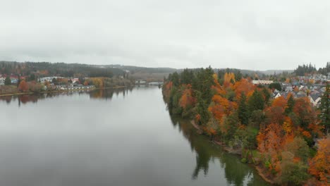 Aerial-view-of-traditional-colorful-houses-in-coastal-town-by-calm-lake-in-north-America