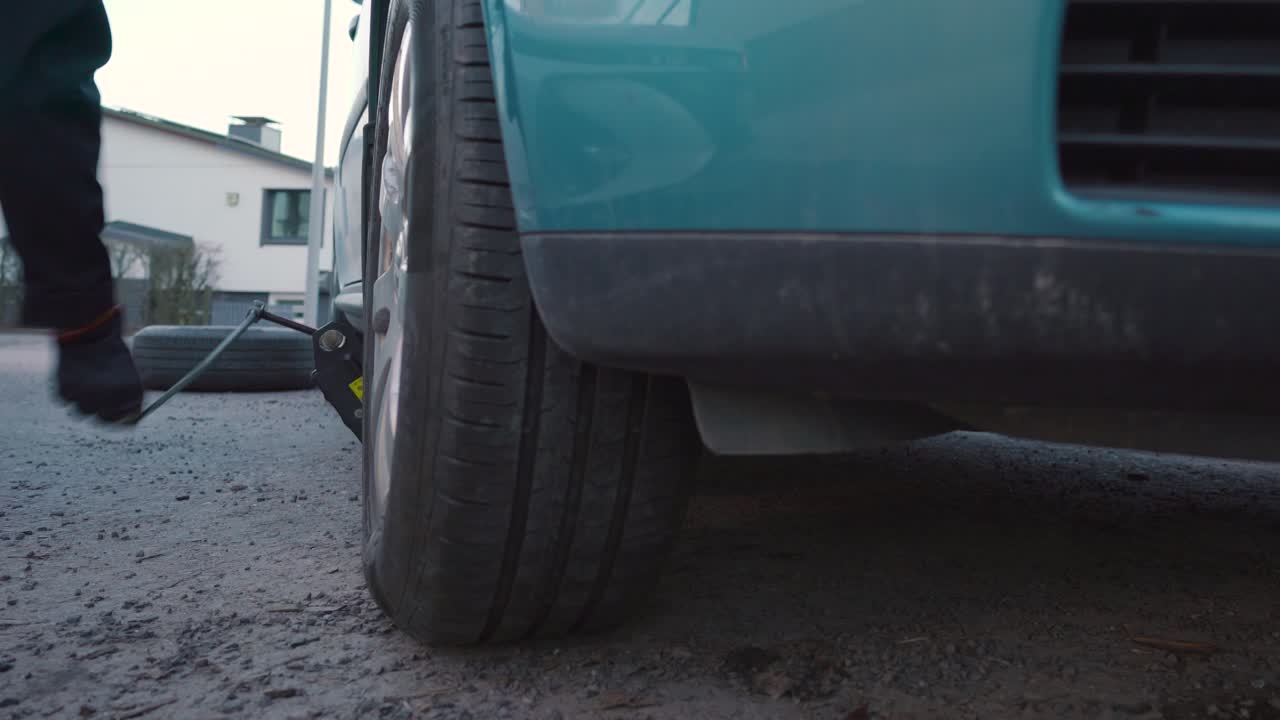 hombre bajando un coche de nuevo al suelo