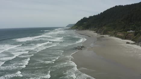 Slow-wide-drone-tracking-shot-of-expansive-ocean-beach