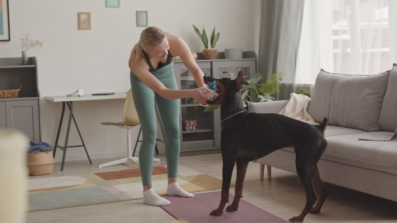 Sportswoman Fighting for Bottle with Dog