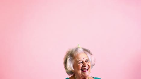행복한 고령 여성이 풍선과 모자와 함께 생일을 축하하고 있습니다.