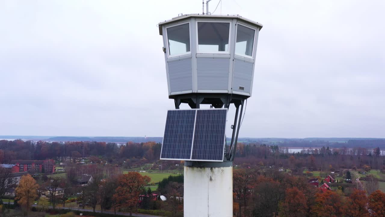 vieja torre de vigilancia de bomberos con instalación de paneles solares vista aérea descendiendo del poste al paisaje rural de otoño